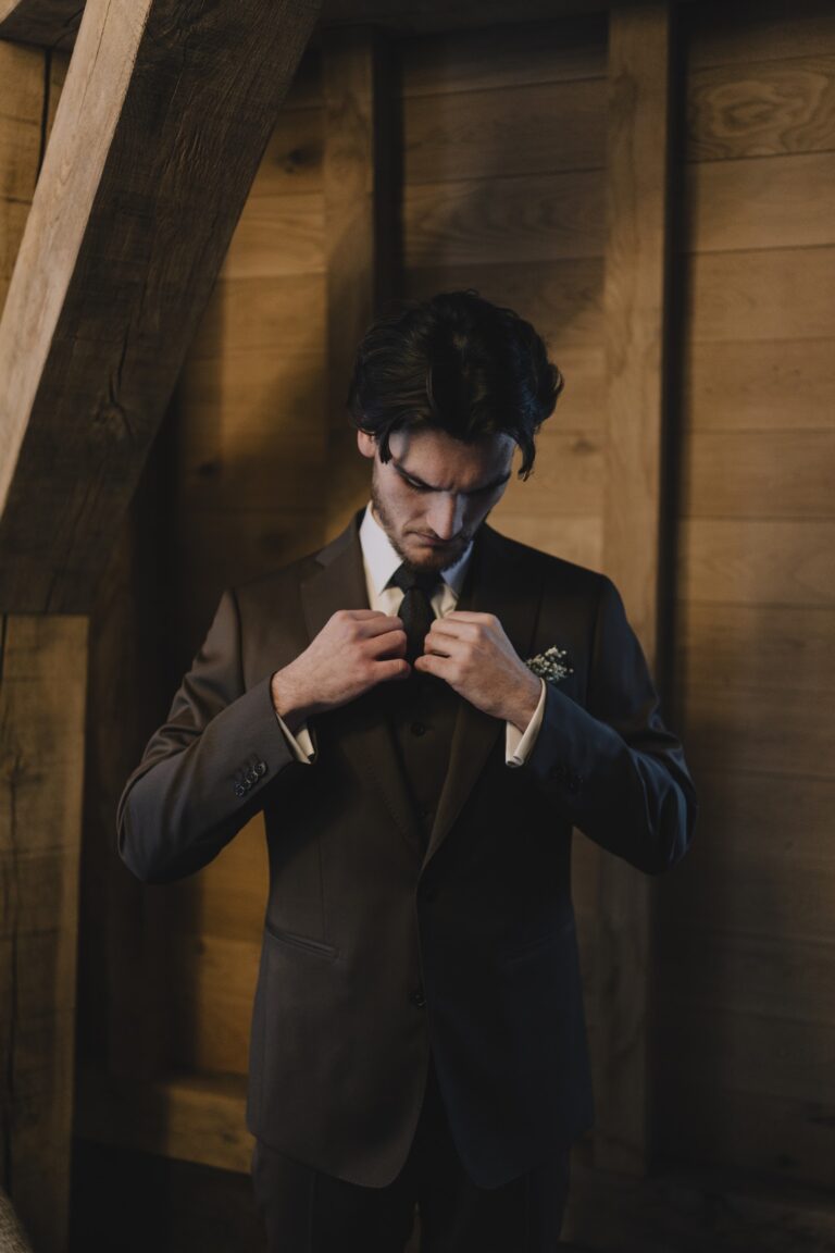 Quentin boutonne son gilet sur mesure, sous les poutres